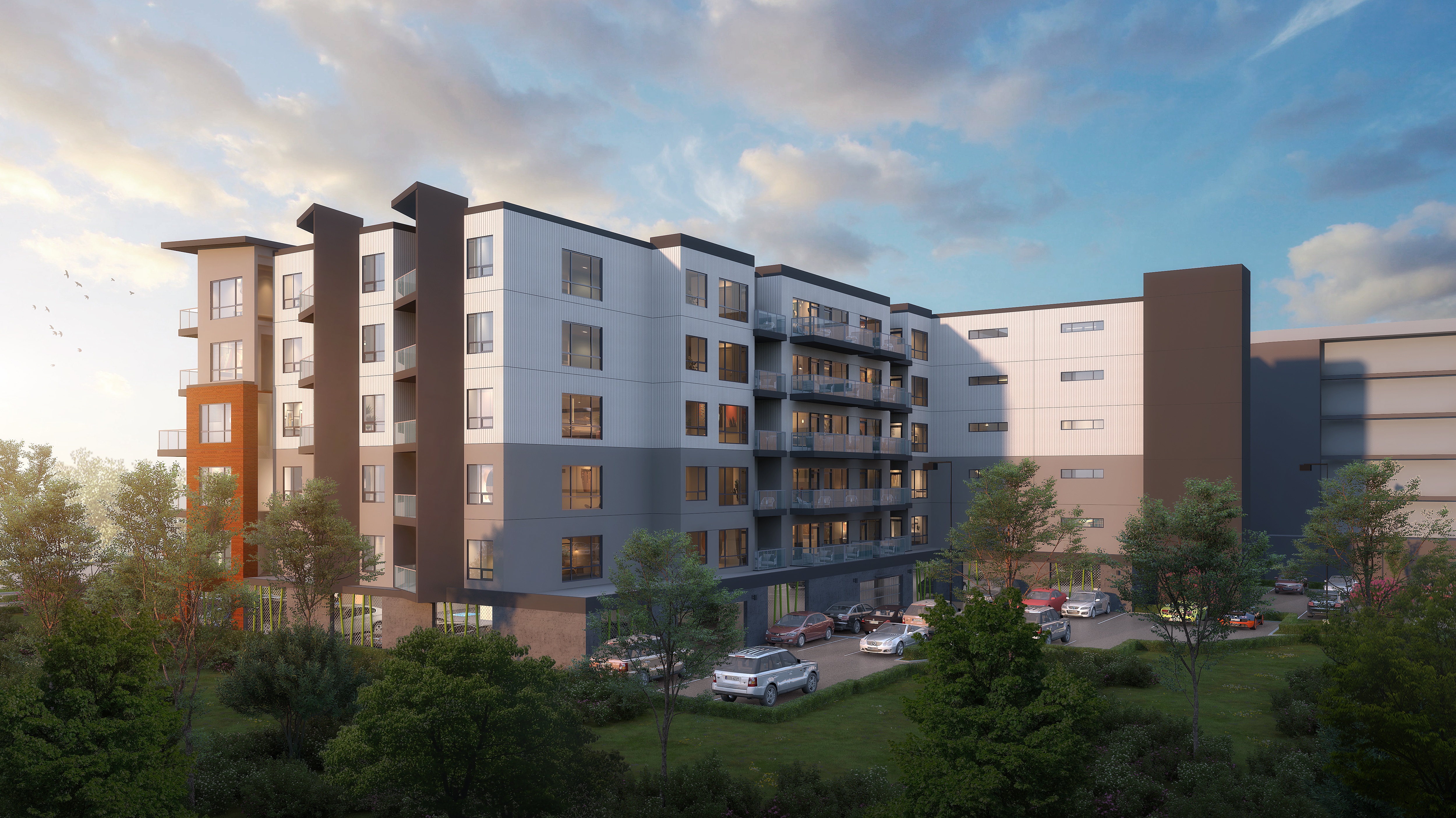 A modern apartment complex with multiple buildings and a parking lot in front.